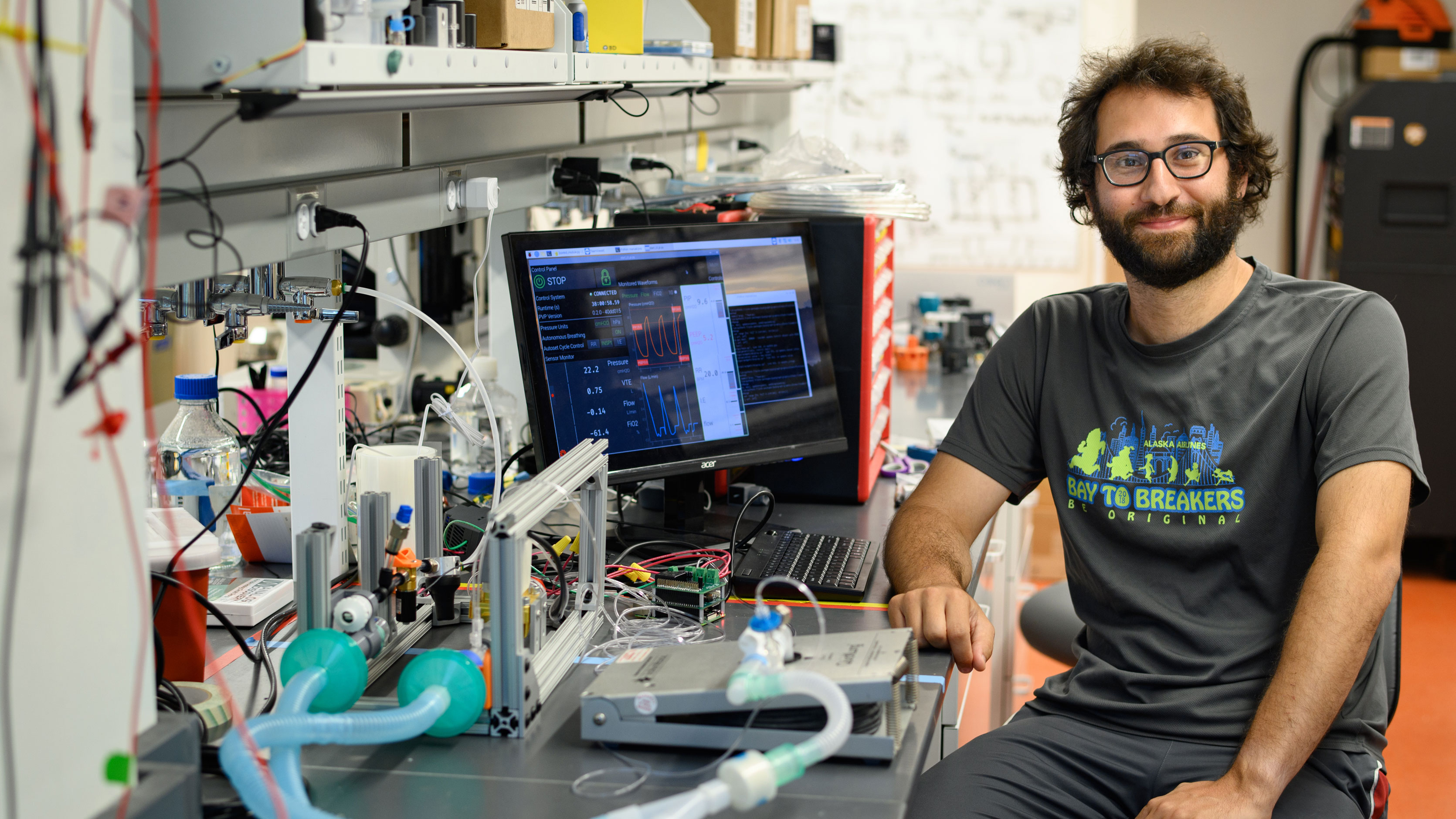 Tom Zajdel sitting in a lab in front of a computer and lab equipment.