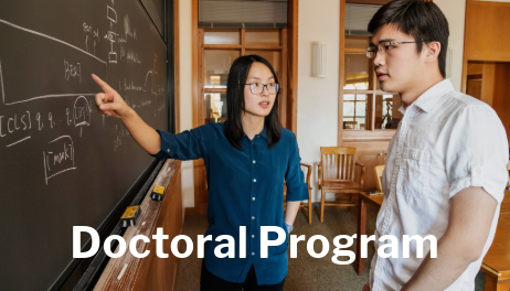 Doctoral Program - faculty pointing at blackboard talking to a student